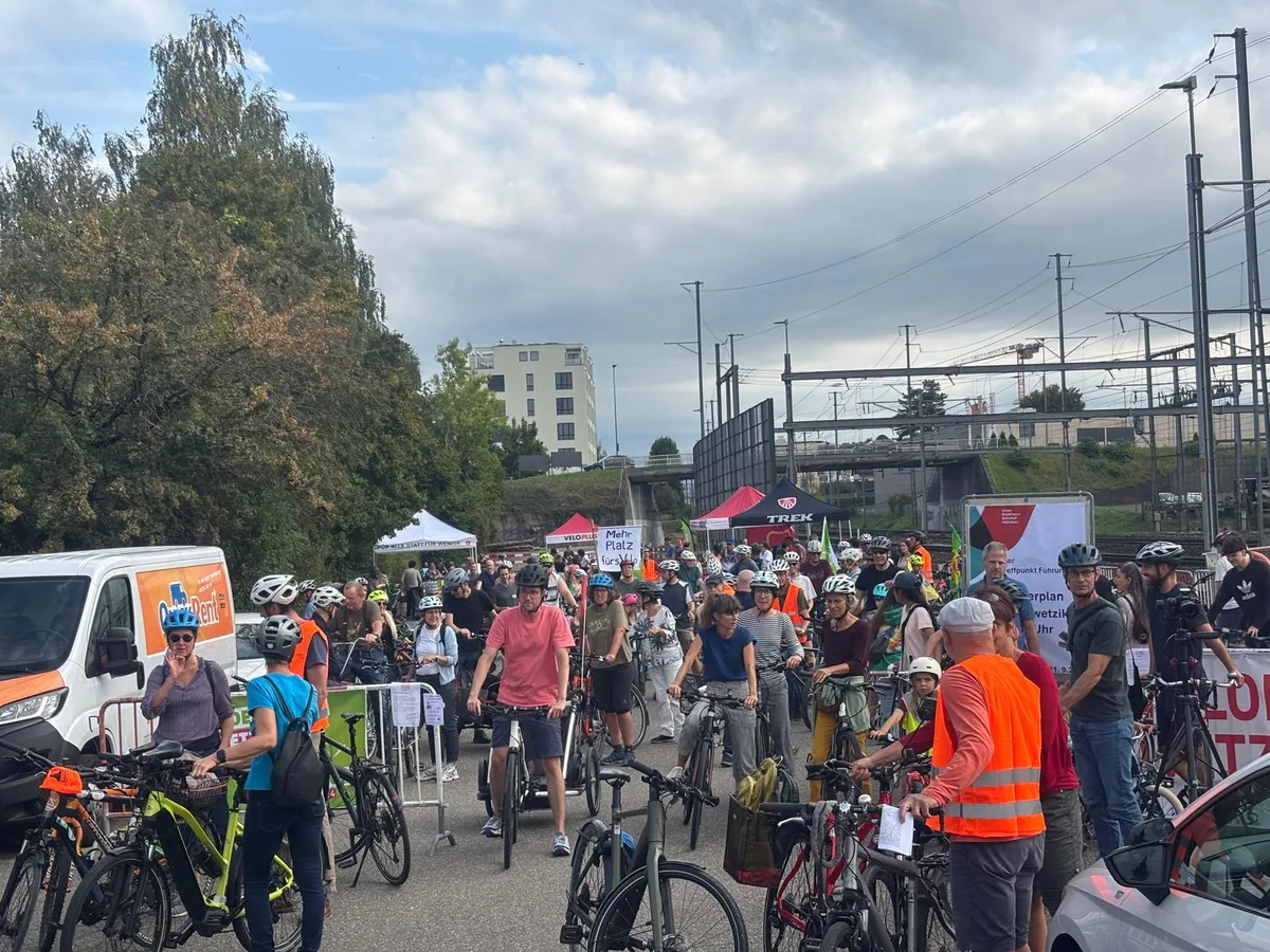 In der Menge sind fast nur Velohelme auszumachen. Die Teilnehmer sind versammelt und bereit für die Abfahrt auf dem Velo.